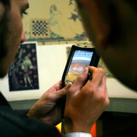 Students using mobile phone to study images at a museum